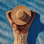 Frau mit Sonnenhut liegt entspannt am Pool | Elfa Master